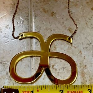 2.5 x 2 inch gold mirrored logo necklace. Stand out and be bold!